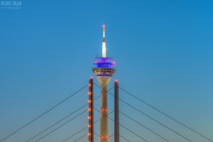 Rheinturm in Düsseldorf eingerahmt von den Säulen der Rheinkniebrücke